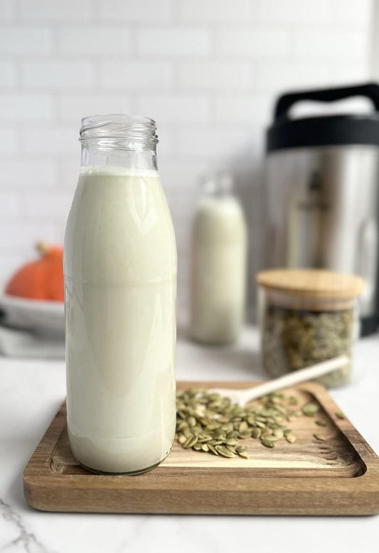 Glass bottle filled with fresh homemade pumpkin seed milk